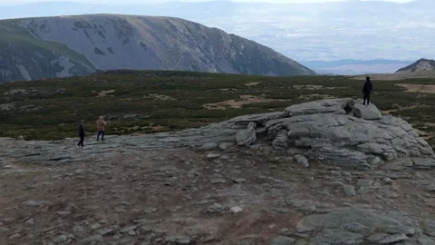 Backwards reveal of hikers exploring the natural beauty of Serra da Estrela Stock Footage 296009686