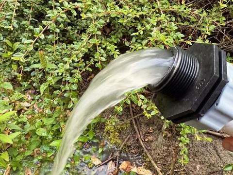 Backwashing the pool water through the sand filter system shows dirty water.. Stock Photos