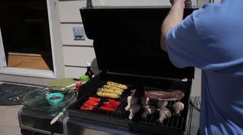 Backyard Barbeque man opens grill with chicken, corn, steak - 3 clips Stock Footage 37624329