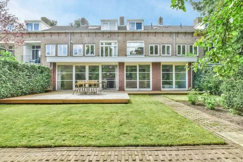 A backyard with a deck and a brick house Stock Photos