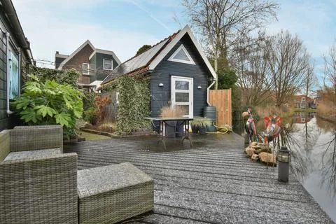 A backyard deck with a small house and a table Stock Photos