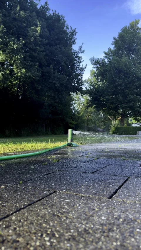 Backyard Garden with Coiled Hoses, Sprinkler Watering Lawn During a Heatwave Stock Footage 340238439