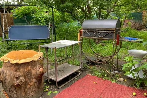 Backyard with grill BBQ, swing, table and tree stump, simple resting zone i.. Stock Photos