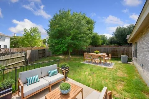 The backyard has a patio with a couch, table, and chairs Stock Photos