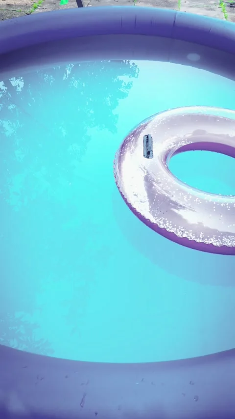 Backyard inflatable pool water. Purple pool rim and clear blue surface creating Vídeo Stock 342501404