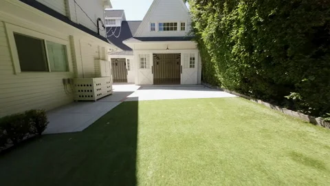 Backyard lawn with stone path and white carriage house Stock Footage 345699922