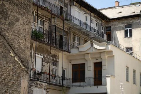Backyard of an old poor worn building with flats and fancy windows Stock Photos
