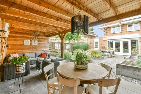A backyard patio with a table and chairs Stock Photos