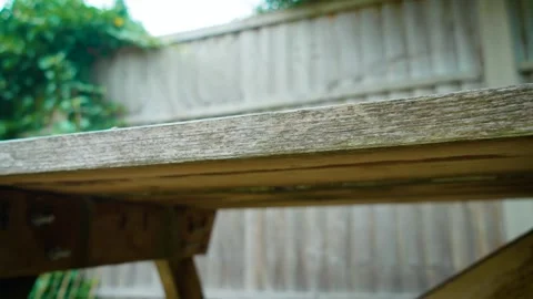 Backyard picnic table seating area within landscaped garden space. Aged wooden Stock Footage 337418318