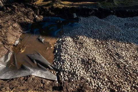 Backyard pond construction with liner and crushed stone base Stock Photos
