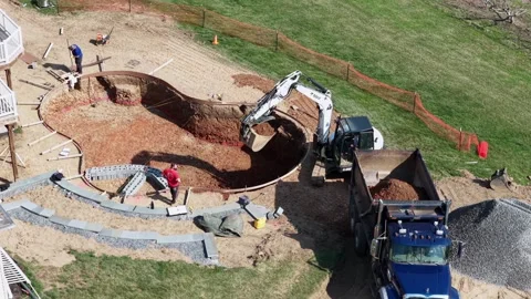 Backyard pool construction site in Lancaster , PA, USA, with an excavator, work Stock Footage 333611250