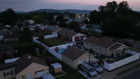 Backyard pool sits beside single story homes with cars in driveways in Lehigh Stock Footage 340970825