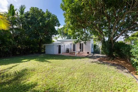 Backyard Surrounded by large vegetation short grass, stone paths Stock Photos