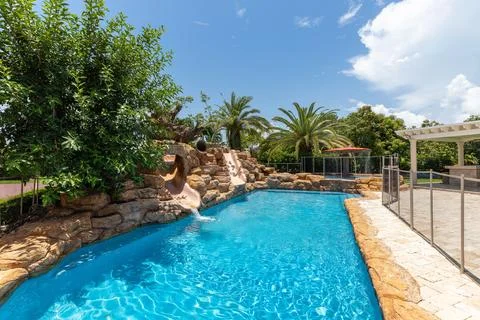 Backyard Surrounded by large vegetation short grass, stone paths Stock Photos