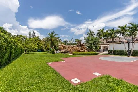 Backyard Surrounded by large vegetation short grass, stone paths Stock Photos