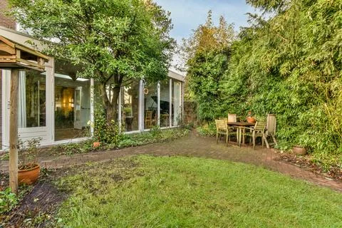 A backyard with a table and chairs and a house Stock Photos