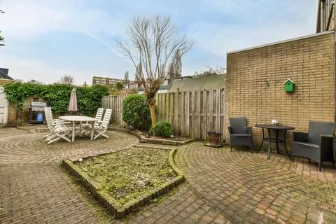 A backyard with a tile pattern on the path Stock Photos