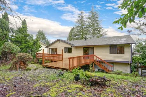Backyard view of a spacious two story home with large entertainment deck. Foto stock