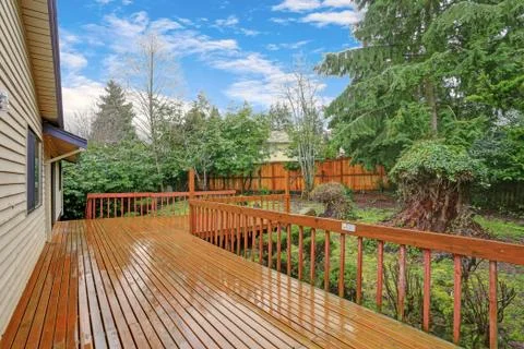 Backyard view of a spacious two story home with large entertainment deck. Stock Photos