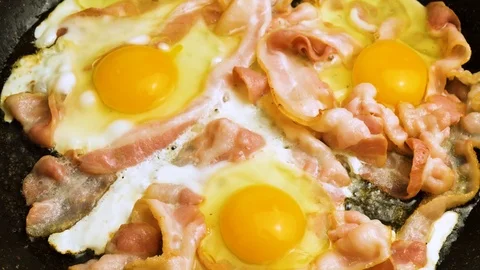 Bacon and eggs in a pan sprinkle with salt Stock Footage 126171795