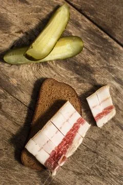 Bacon, bread and cucumber over wooden background 스톡 사진