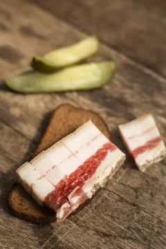 Bacon, bread and cucumber over wooden background Foto stock