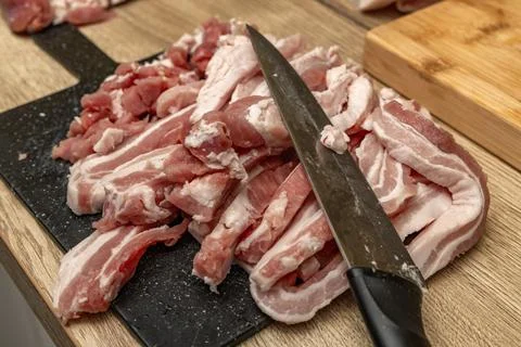 Bacon cut into thin pieces, bacon cubes, preparing ingredients for lard in .. Stock Photos