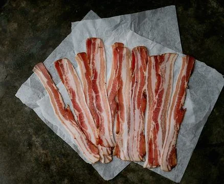Bacon on a dark rustic background Stock Photos