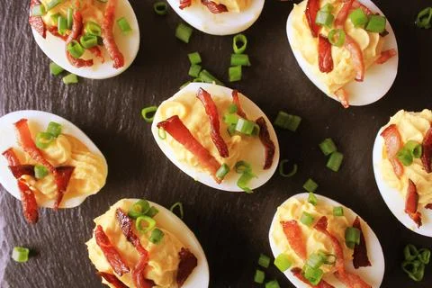 Bacon Deviled Eggs on black background Stock Photos