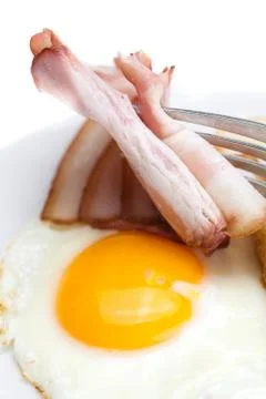 Bacon with  fried  eggs on a plate, fork and bread isolated on white Stock Photos