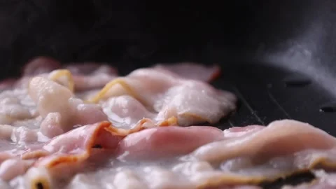 Bacon is fried in a frying pan Stock Footage 176390250