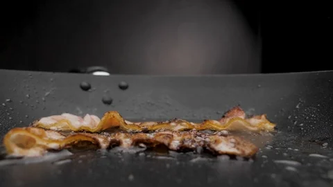 The bacon is fried in a pan. Video stock 117778896