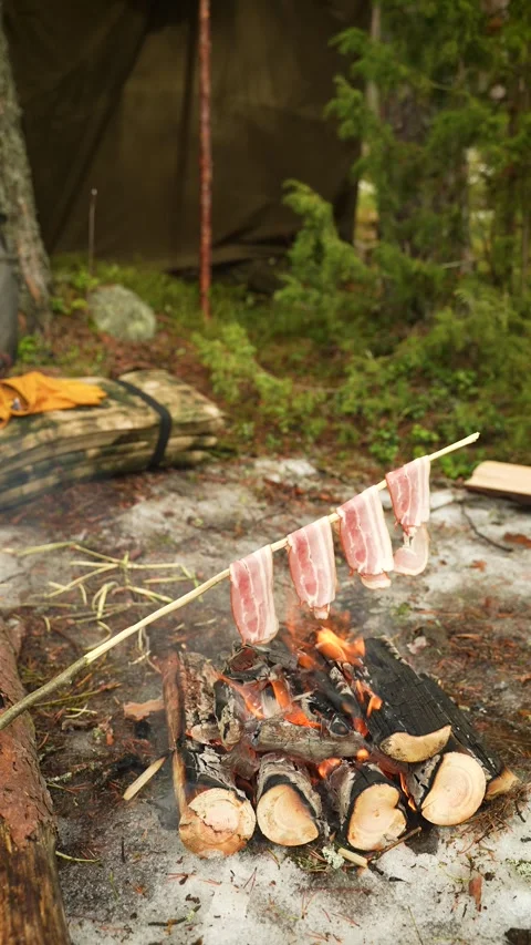 Bacon is frying over the fire. Cooking food in the wilderness. Cooking bacon Video stock 307007948