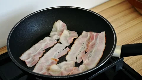 Bacon frying in a pan closeup 4K Stock Footage 168986429