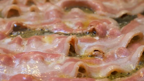 Bacon frying in pan Stock Footage