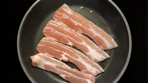 Bacon frying in a pan. Top view. Zoom. The rotation of the camera. Stock Footage 67715686