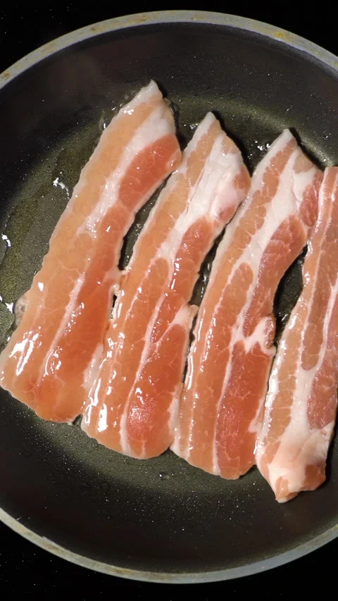 Bacon frying in pan. Top view. Zoom. The rotation of the camera. Stock Footage 267887064