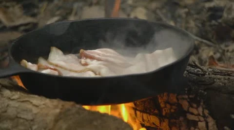 Bacon Frying in a skillet on a fire Stock Footage 8955823