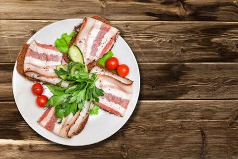 Bacon with herbs and tomatoes Stock Photos