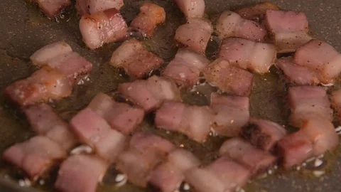 Bacon pancetta roasting/frying  on the oil on the pan, close up Stock Footage 123804293