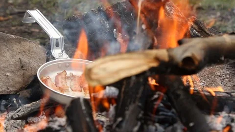 Bacon Sizzling on Open Fire While Camping Tracking Stock Footage