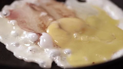 Bacon slices, egg are fried on the stove. Stock Footage 146335840