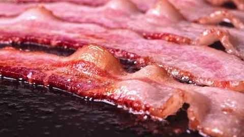 Bacon slices sizzle and bubble in frying pan. easy to cook bachelor breakfast. 스톡 동영상 334642629