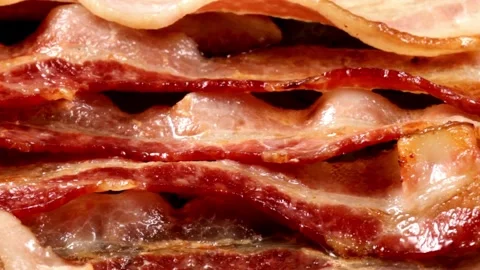 Bacon strips being cooked for breakfast. A pile of Fried bacon slices, closeup. 스톡 동영상 334641581