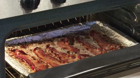 Bacon strips cooking on a baking sheet inside an oven Stock-Footage 330015107