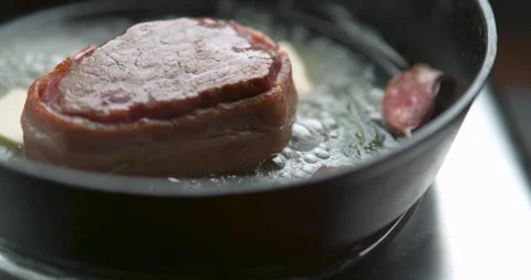 Bacon-wrapped beef tournedos, cooked in butter, garlic and thyme, in a deep fryi Stock Footage 199459530