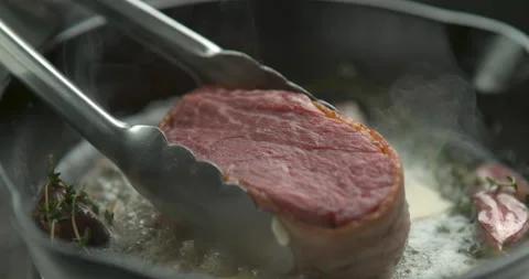 Bacon-wrapped beef tournedos, cooked in butter, garlic and thyme, in a deep fryi Stock Footage 199459887