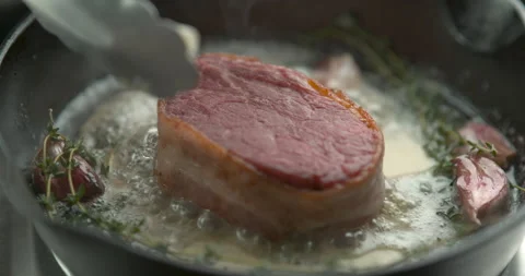 Bacon-wrapped beef tournedos, cooked in butter, garlic and thyme, in a deep fryi Stock Footage 199462521
