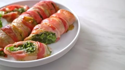 Bacon-wrapped vegetable rolls on a white plate Stock Photos