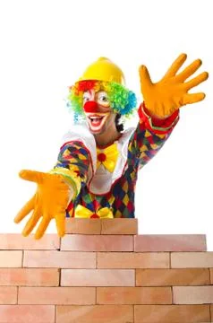 Bad construction concept with clown laying bricks Foto stock